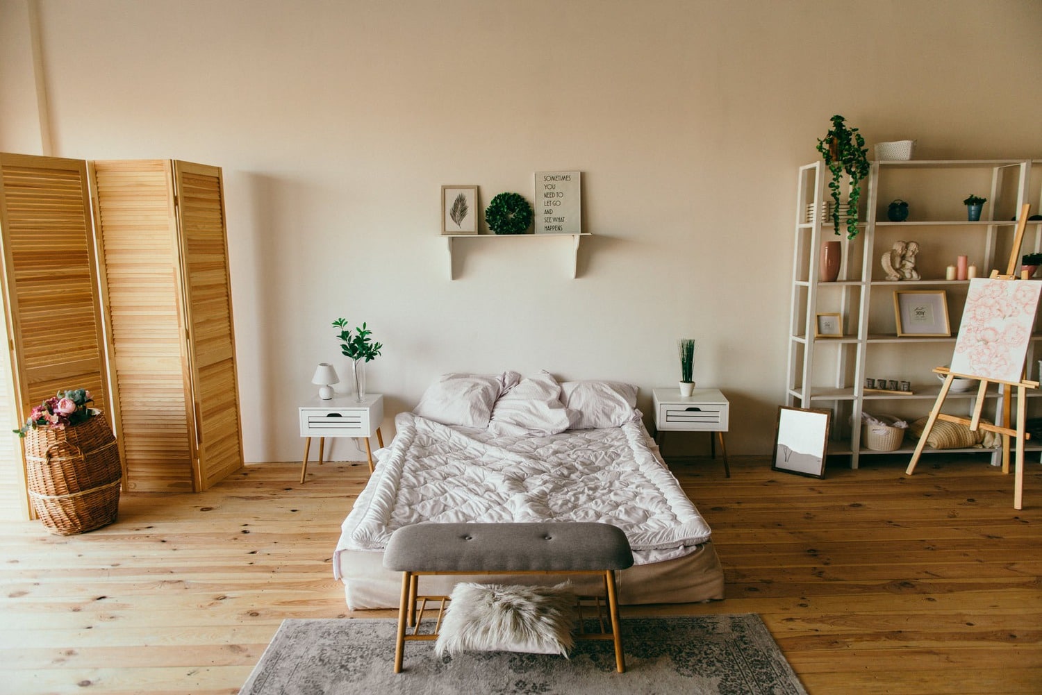 big bedroom area with bed, bench and shelves.