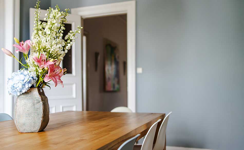 There are fresh flowers on dining table.