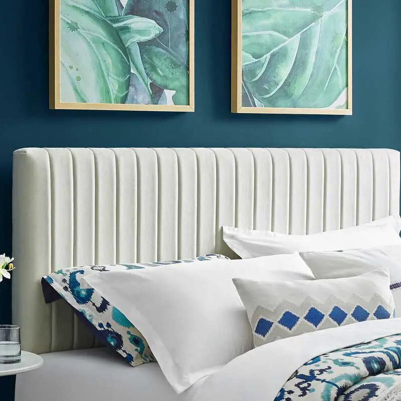 Upholstered panel headboard with dark blue wall.