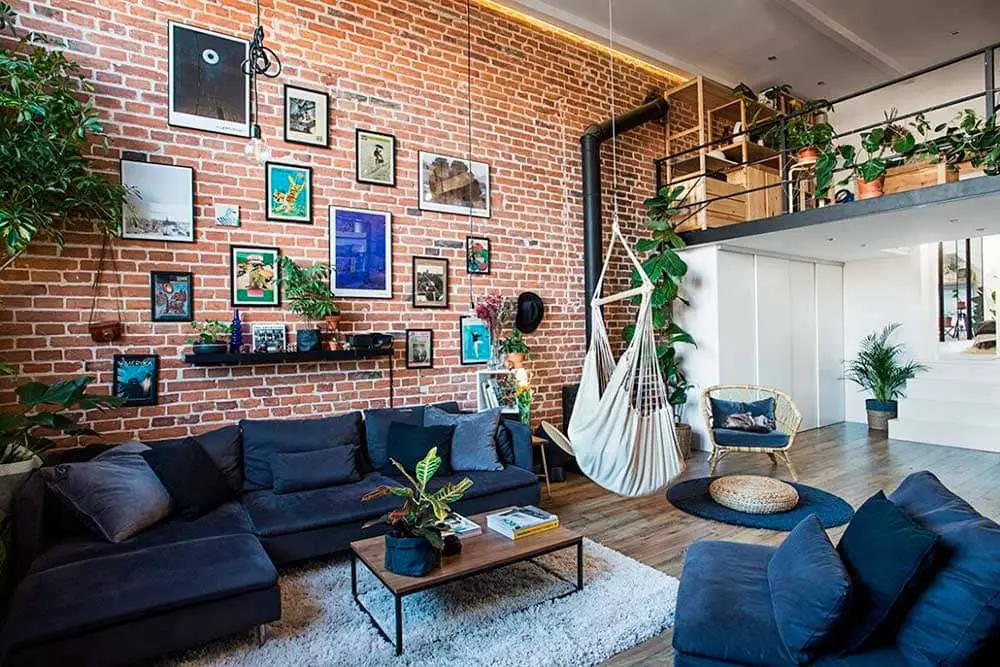 A loft apartment with hanging planters and dark blue sofa set.