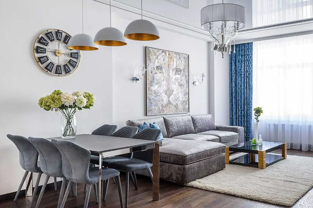 The living room with dark flooring and bright walls.