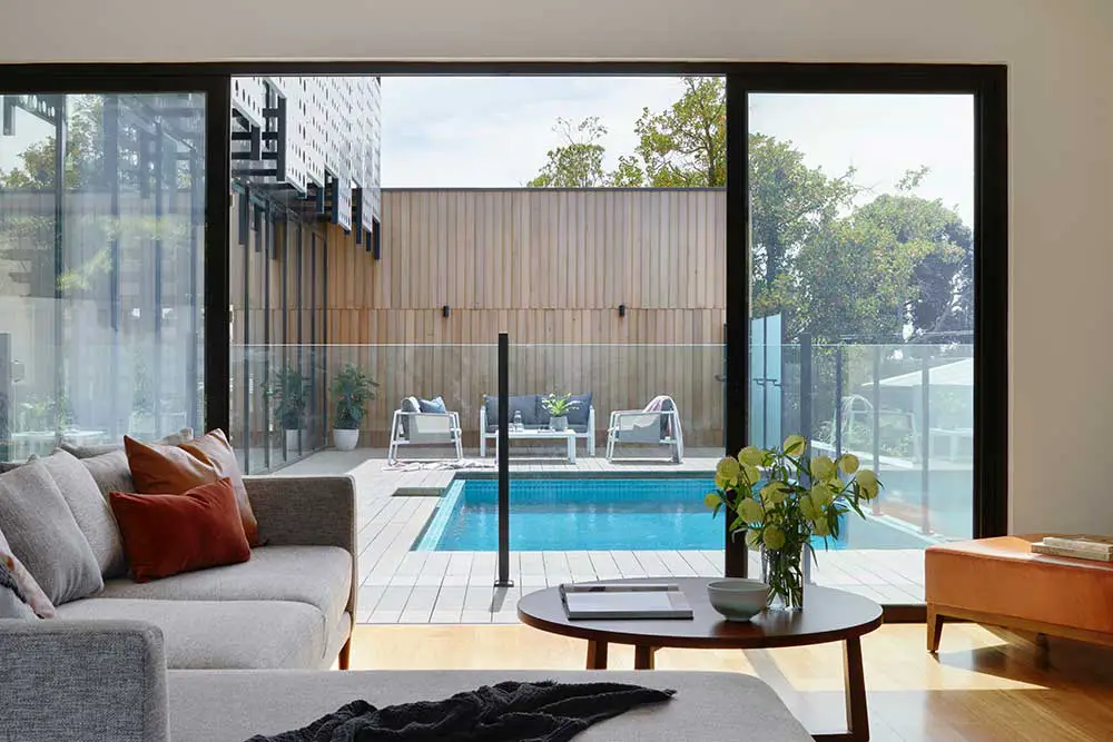 Canapé sectionnel contre la fenêtre et vue sur la piscine.
