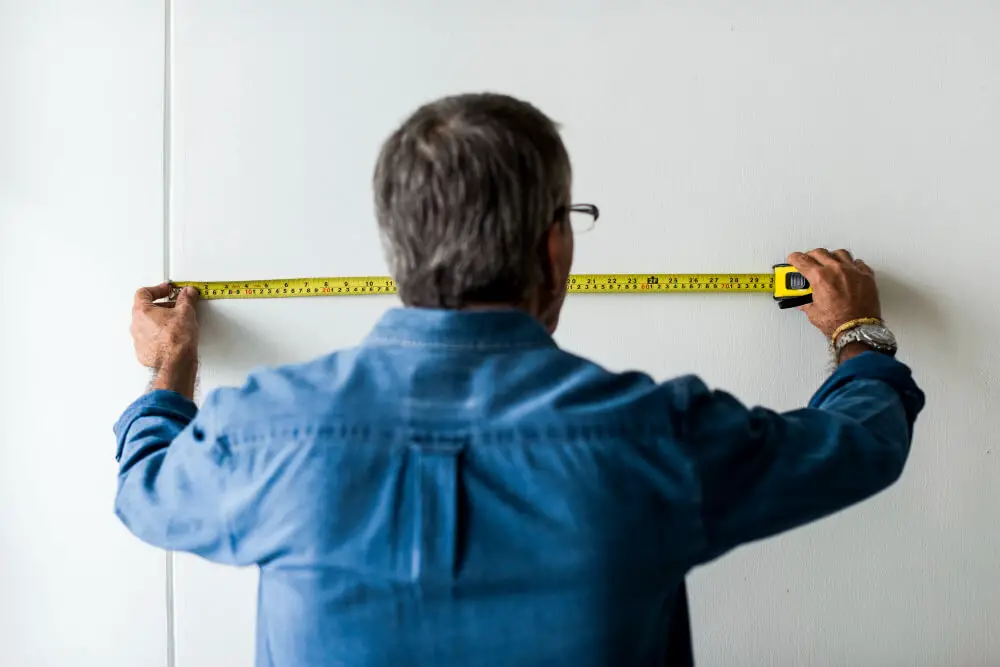man measuring wall